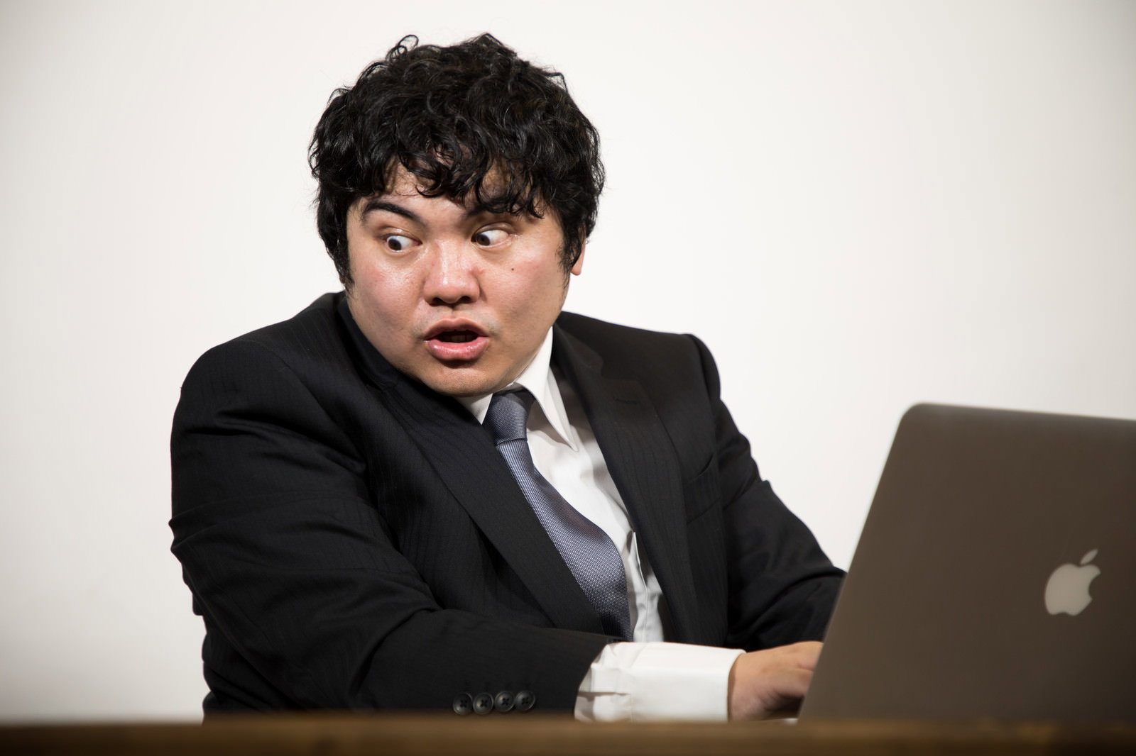 仕様書を見て驚く男性エンジニア［モデル：段田隼人］