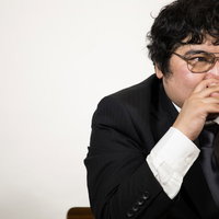 真剣な眼差しで部下のプレゼンを聞く会社役員の写真