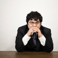 自宅で陣頭指揮を取る総司令が机で考える男性の写真