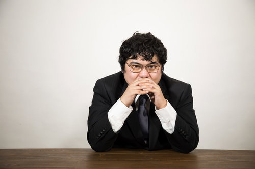 自宅で陣頭指揮を取る総司令が机で考える男性