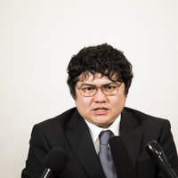 「私利私欲でそのような体型になられたのですか？」とマスコミに指摘され、険しい表情に変わる役員の写真