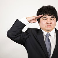 敬礼する男性のビジネスマンのポーズ、スーツ姿の正装の写真