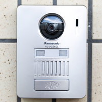 白い壁に設置されたカメラ付きのインターホンの写真