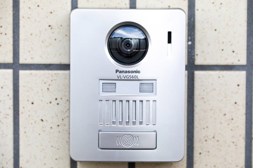 白い壁に設置されたカメラ付きのインターホン