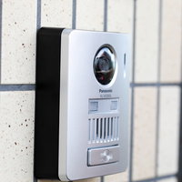 玄関前に設置されたシルバーのインターホンの写真