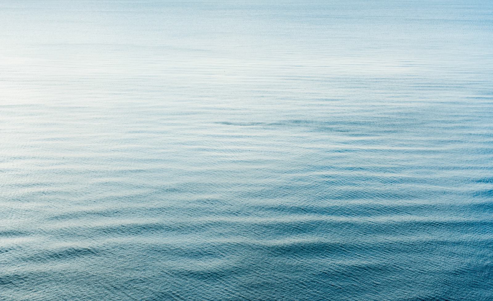 青から水色のグラデーションが美しい穏やかな海の水面