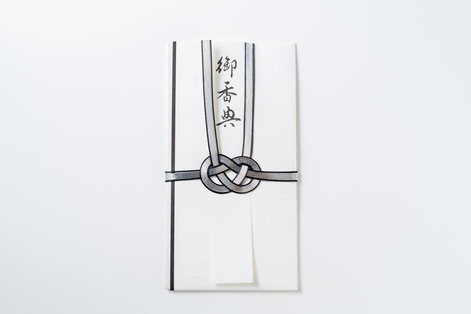 White condolence envelope tied with a formal knot of black and white mizuhiki