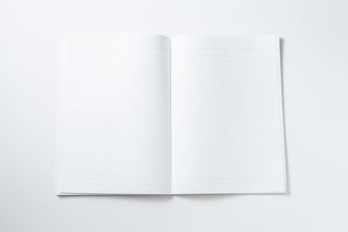 何も書かれていない真っ白な見開きノートと文具の背景デザイン