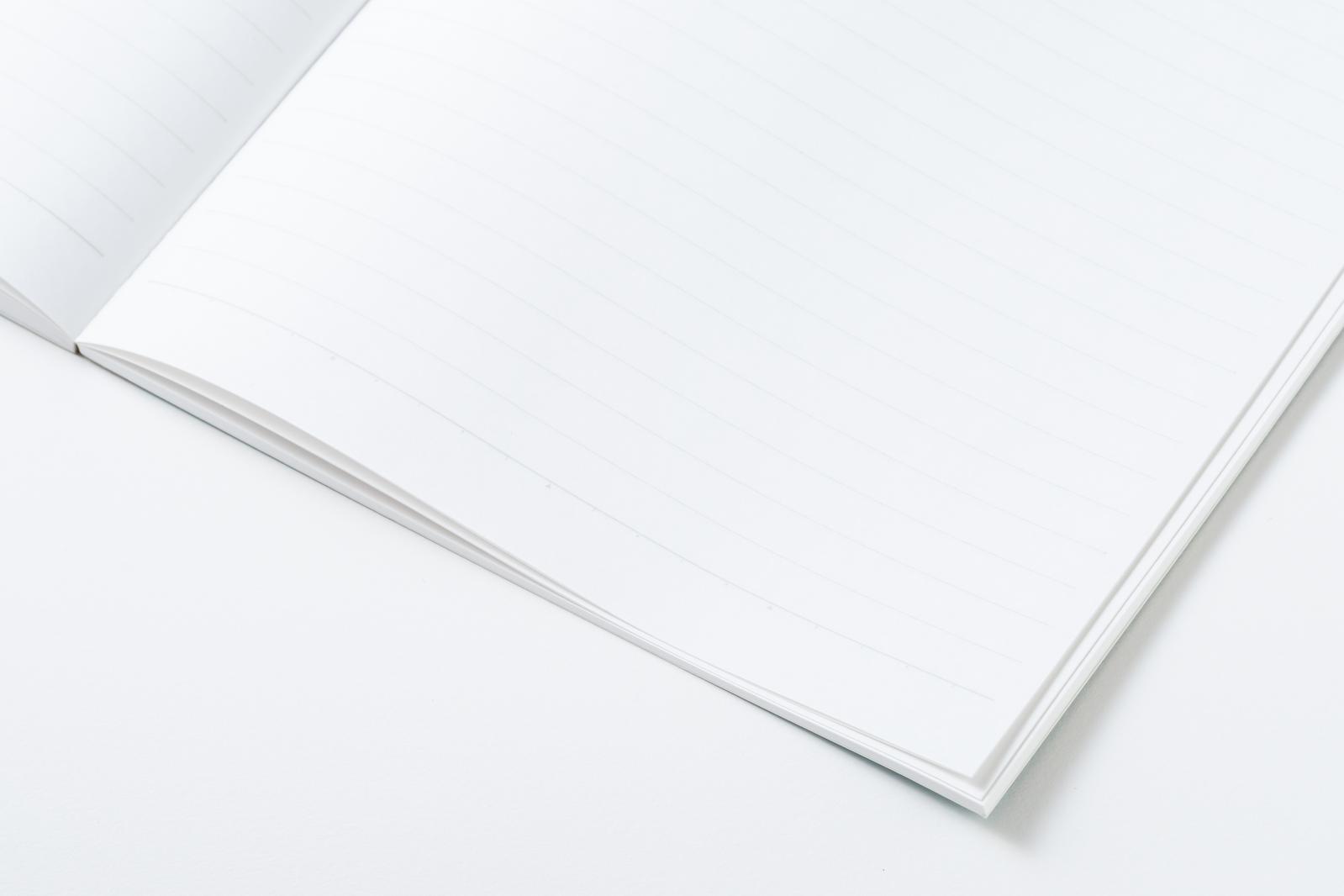 An open notebook placed on a white background, with blank, white pages spread open in a double-page spread.