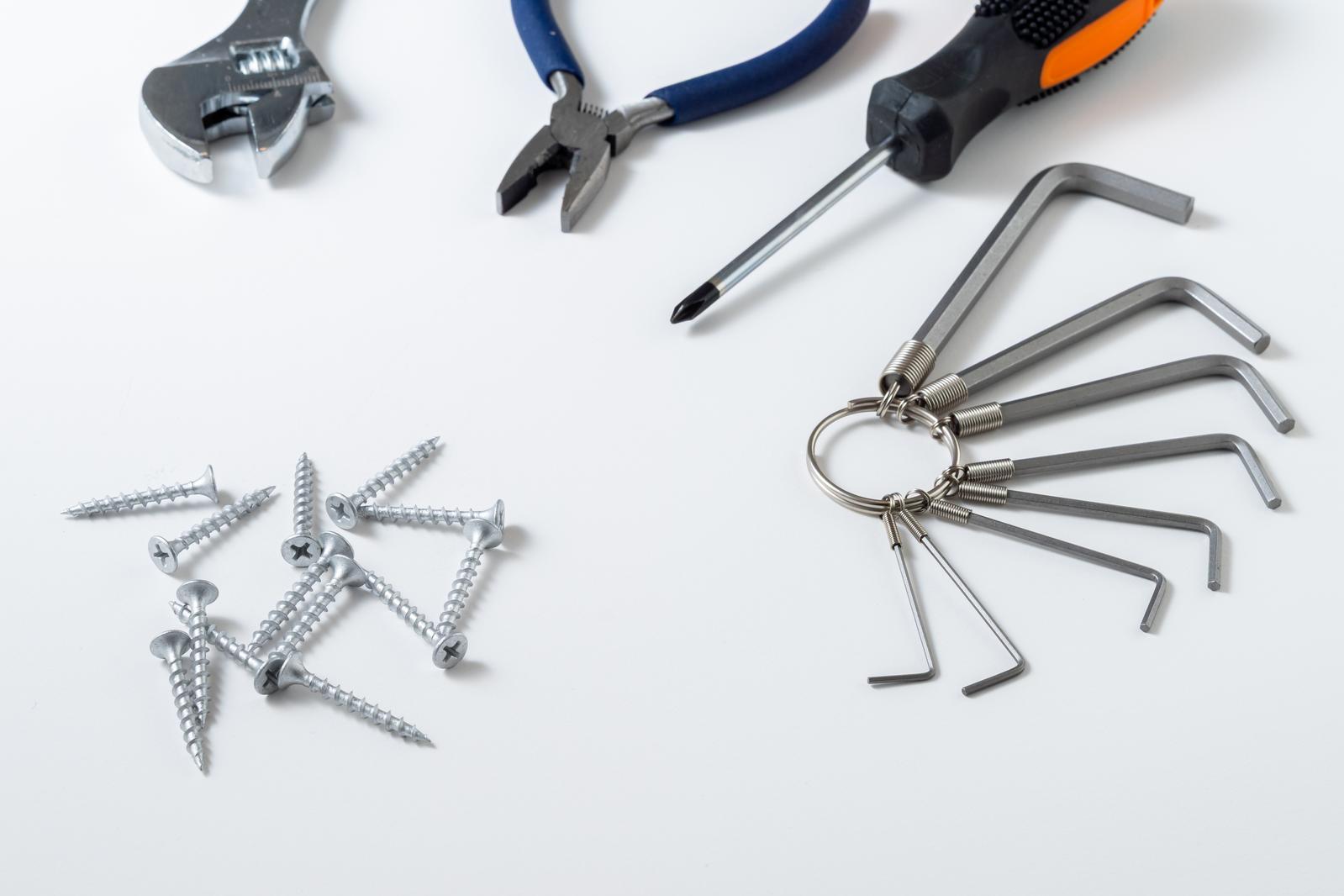 Monkey wrench, pliers, screwdriver, hex wrench set, and other tools arranged on a white background