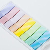 レインボーカラーの付箋が透明プラスチックケースに整理された状態の写真