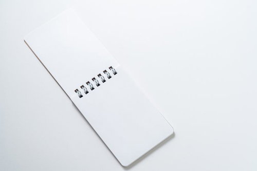 クラフト紙のリングノートと清潔な白背景の文具