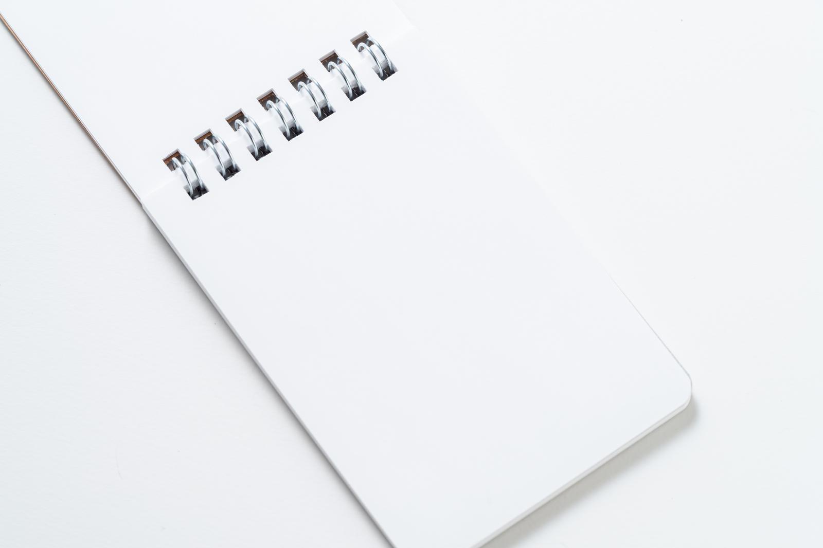 A simple notebook with an impressive silver spiral binding against a white background