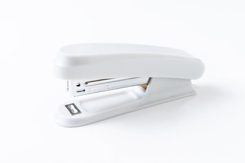 白背景に置かれた上部が開いた白いホッチキス