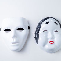 対照的な表情の白いお面と黒いヘッドフォンの写真