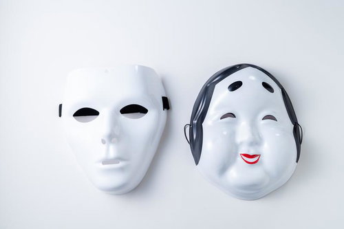 対照的な表情の白いお面と黒いヘッドフォン