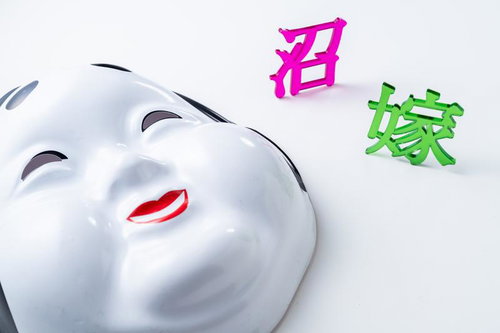 笑顔のおたふく面と無表情の白いお面の対比