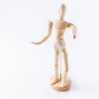 右手を前に伸ばし左手を腰に当てるポーズの木製デッサン人形の写真