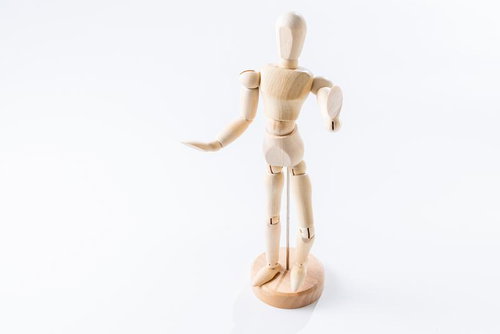 右手を前に伸ばし左手を腰に当てるポーズの木製デッサン人形