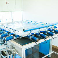 シルクスクリーンの紗張り作業台に並ぶ青いフレームの写真