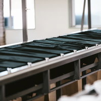 シルクスクリーン印刷工場の長台に置かれた黒Tシャツの写真