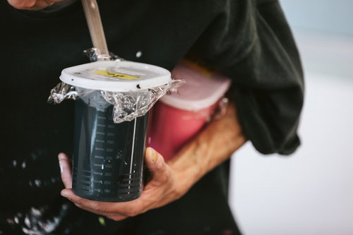 シルクスクリーン印刷用のカラフルな水性インキを手に持った職人