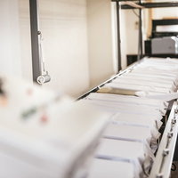 シルクスクリーン印刺の工場に並ぶ白い長台の写真