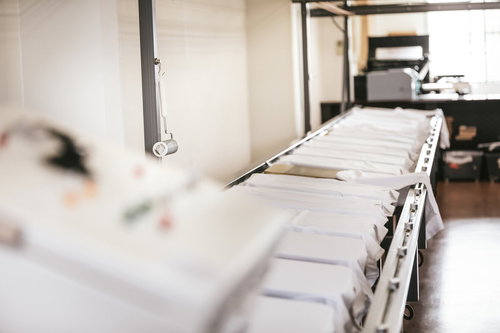 シルクスクリーン印刺の工場に並ぶ白い長台