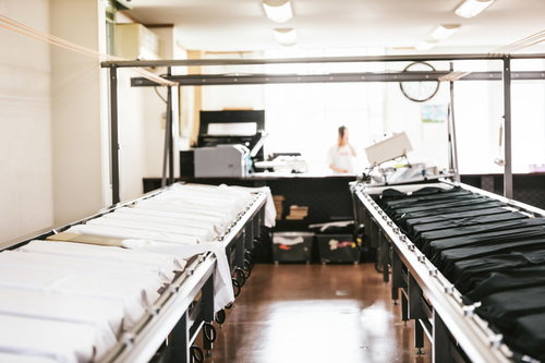 シルクスクリーン印刷の設備台に置かれた白黒のティーシャツ