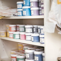 棚に並ぶシルク印刷用の多色インキ、赤や青、黄色などの色見本の写真