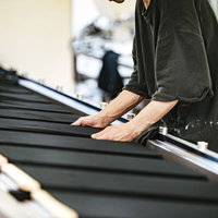 長台に置かれた黒いTシャツのシワを伸ばすシルク印刷の職人の写真