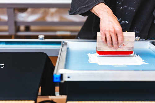 シルクスクリーン印刷でスキージを使う職人の手元