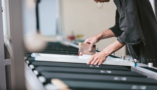 塗っては乾燥させる作業を繰り返すシルク印刷の職人