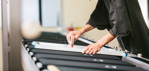 スキージを繰り返し使って着色するシルクスクリーン印刷の職人