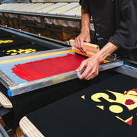 手刷りでTシャツに着色するシルクスクリーン印刷の現場の写真