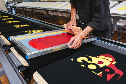 手刷りでTシャツに着色するシルクスクリーン印刷の現場