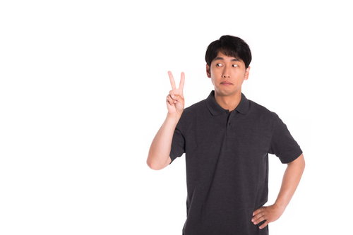 2本指を見つめる男性のピースサイン、2番順位を示すジェスチャー