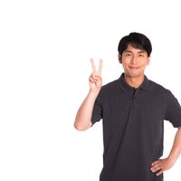 笑顔でピースサインをする男性の写真