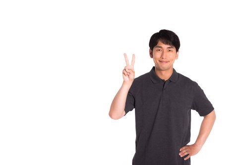 笑顔でピースサインをする男性