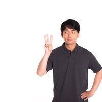 ランキング3位を示す3本指を立てるグレーポロシャツの男性の写真