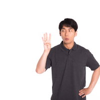 4本指を立てて4番を示す男性の写真
