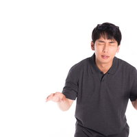 額に乗せたメガネを探す困惑した男性のポロシャツ姿の写真