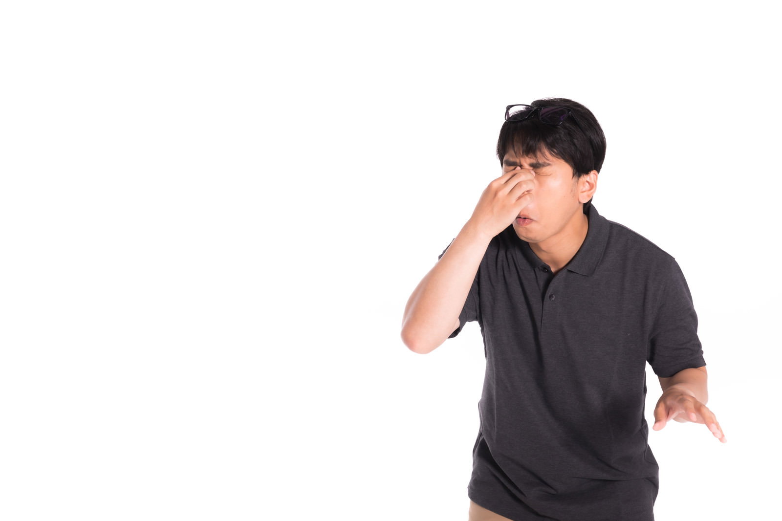 目頭を押さえて眼精疲労をケアする黒い眼鏡をかけた男性［モデル：大川竜弥］