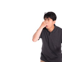 眼精疲労で目頭を押さえる眼鏡をかけた男性の写真