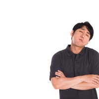 納得がいかない様子で腕を組むクレーマー男性の写真
