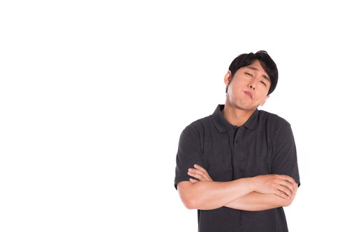 納得がいかない様子で腕を組むクレーマー男性