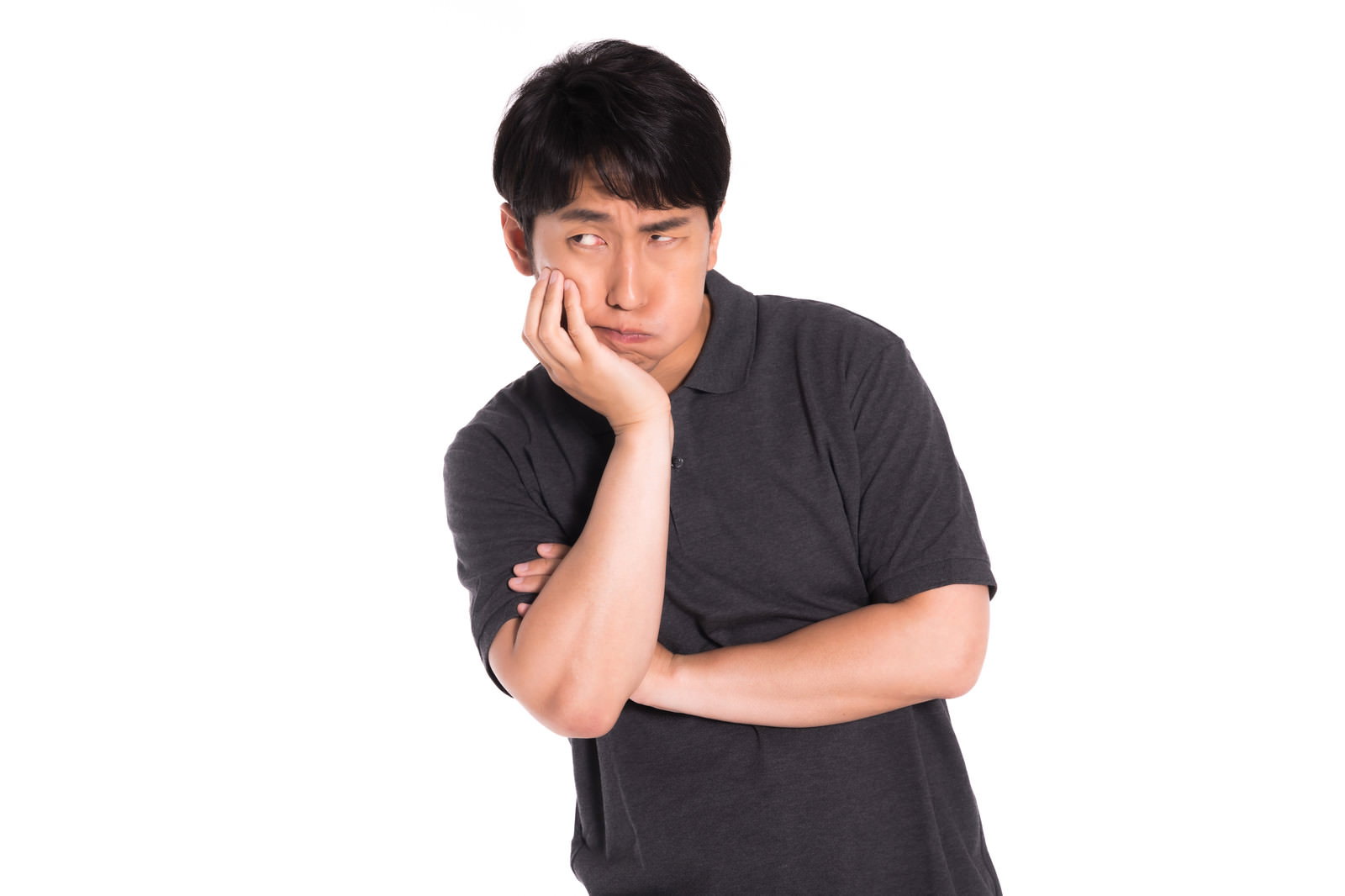 黒いTシャツを着た男性が右手で頬杖をついて考え込んでいる様子［モデル：大川竜弥］