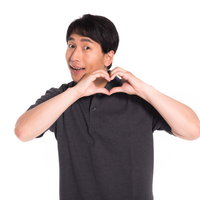 両手でハートマークを作る笑顔の男性のポートレートの写真