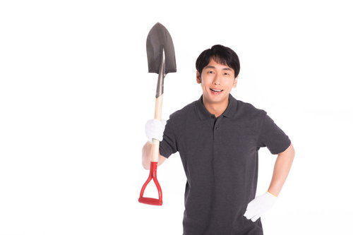 今から埋めちゃうぞ！シャベルを持って笑顔の男性