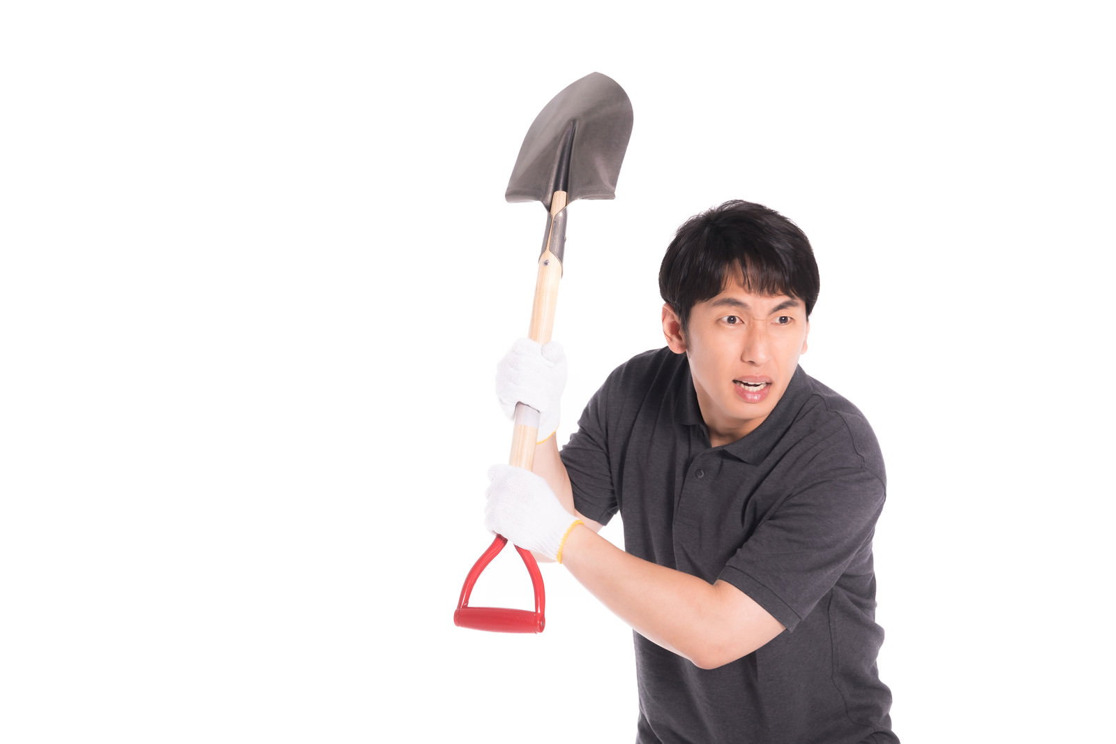 黒いTシャツを着た男性が赤い柄のシャベルを片手で振り上げている［モデル：大川竜弥］